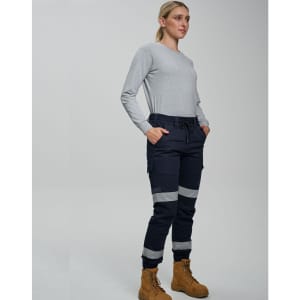 Cotton stretch drill cuffed work pants in navy with reflective tape, worn by a model with a grey long-sleeve top and boots.
