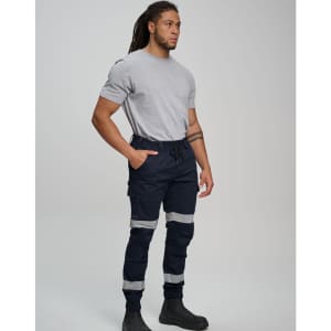 A man wearing navy cotton stretch drill cuffed work pants with reflective tape, paired with a grey t-shirt and black boots.