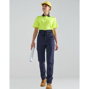 A pair of navy work pants with a flexible fit, worn with a fluorescent yellow polo shirt and a hard hat.