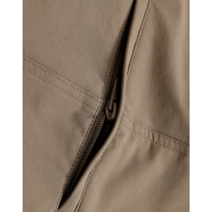 A close-up of beige work pants featuring a zippered pocket, showcasing the fabric and stitching details.