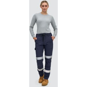 Navy blue work pants with reflective tape, featuring pockets and a comfortable fit, modelled by a woman.