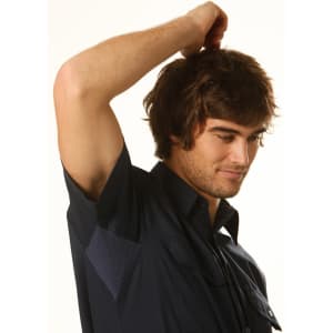 A dark blue short-sleeved cotton work shirt displayed on a young man with tousled hair, featuring a logo on the chest.