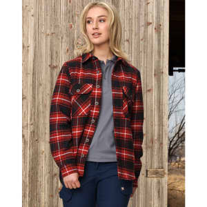 A quilted flannel shirt in red and black check design, featuring buttons and front pockets, worn by a model outdoors.