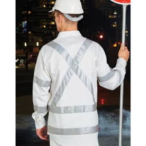 A safety shirt in white with reflective silver stripes, worn by a person holding a stop sign.