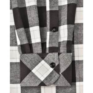 A black and white checkered flannel button-up shirt with a folded cuff, featuring a logo.