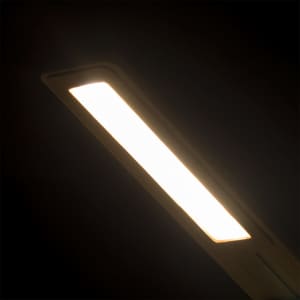A sleek, rectangular wireless charger lamp in a warm white glow, featuring a minimalist design.