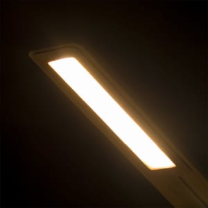 A sleek rectangular lamp emitting warm light, featuring a minimalistic design and soft glow.