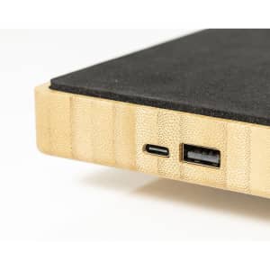 A wireless charger lamp featuring a bamboo base with black surface, showcasing USB-C and USB ports.