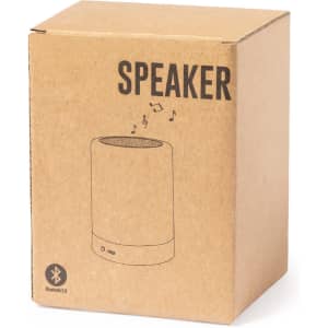 A brown cardboard box containing a cylindrical speaker design with a Bluetooth icon and musical notes illustration.