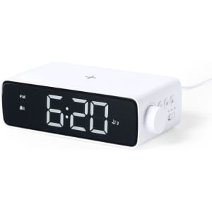 A white multifunction alarm clock with a digital display showing the time and featuring a wireless charging pad.
