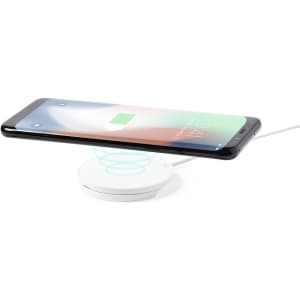 A wireless charger in white, with a smartphone hovering above it, displaying a charging symbol.
