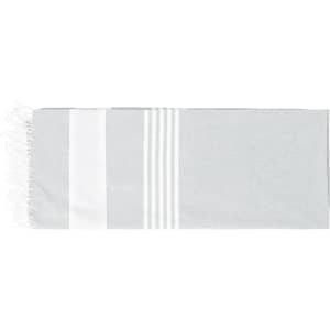 A grey and white beach mat with a striped design and fringed edges. It includes a logo.