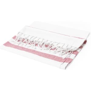 A white and pink striped bath towel with fringe detailing, folded and displayed flat. It features a branding logo.