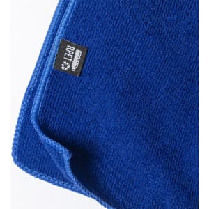 A blue absorbent towel with a textured surface and a small logo tag on the edge.