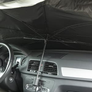 A black sunshade positioned inside a car, featuring a central support pole and an umbrella structure.