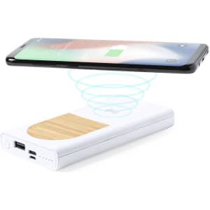 A white power bank with a wooden top, displaying a smartphone above it, indicating wireless charging.