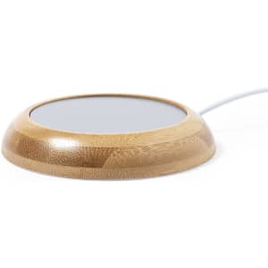 A bamboo cup warmer with a circular shape and a grey top surface, featuring a white power cord.
