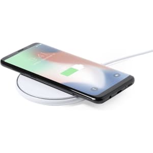 A wireless charger in white, with a smartphone resting on top displaying a charging icon.