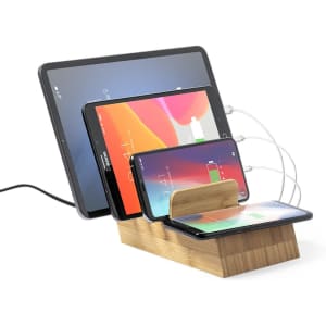 A wooden wireless charger with multiple devices, including tablets and smartphones, connected and charging.
