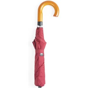 A burgundy umbrella with a curved wooden handle and a logo on the end.
