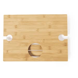 A bamboo table with a smooth surface, featuring two cut-out handles and a circular hole in the centre.