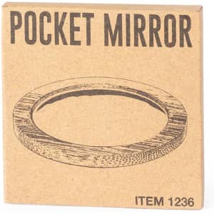 A pocket mirror in a square cardboard packaging with a simple design, featuring natural tones.
