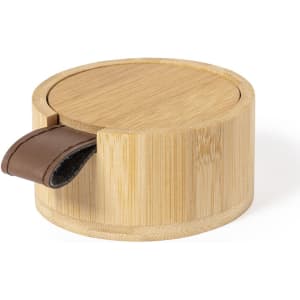 A bamboo jewellery box with a round shape and brown leather handle for easy opening. It features a smooth, natural finish.