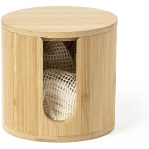 A bamboo cosmetic pad dispenser with a circular design and a cut-out section revealing white mesh pads inside.