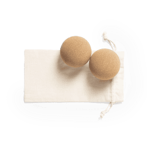 Two tan balls placed on a beige pouch. The pouch has a drawstring for closure.