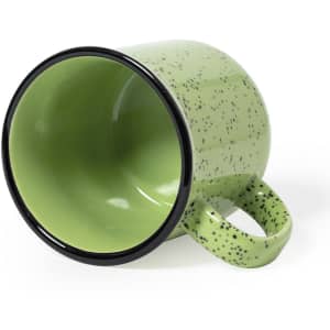 A green speckled coffee mug with a black rim, positioned on its side, showcasing its interior.