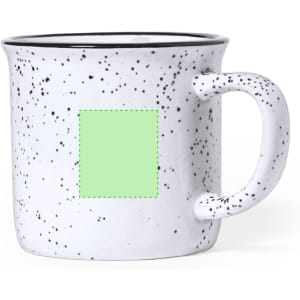 A coffee mug with a speckled white design, featuring a handle and a blank green area for customisation.