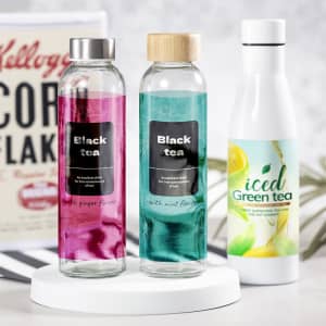 A drink bottle set featuring two clear bottles with pink and teal infused drinks and a white iced green tea bottle.