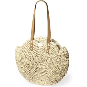 A round, woven tote bag in cream colour with tan straps, featuring a subtle logo.