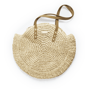 A round, natural straw tote bag with tan leather straps and a simple logo.
