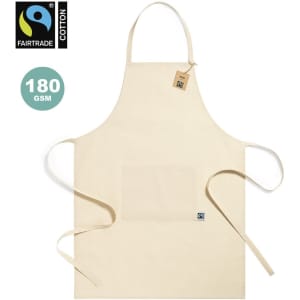 A beige Fairtrade apron made of cotton, featuring a front pocket and adjustable ties, with a logo present.