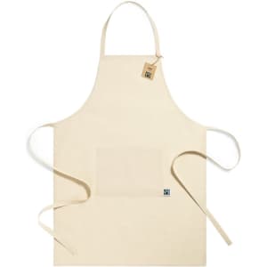 A beige Fairtrade apron with a front pocket and ties on the sides, featuring a logo.