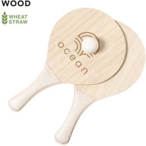 Two wooden beach rackets in light colour, featuring a small ball, with a logo on one racket.