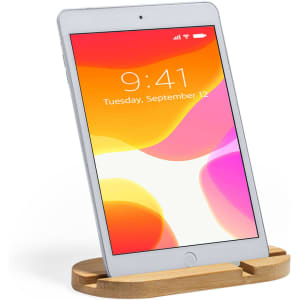 A wooden phone stand featuring a sleek design, holding a tablet with a vibrant screen display.