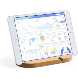 A wooden phone stand supporting a tablet displaying various data graphs and charts. The stand is a light brown colour.