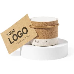 A cork and white container with a hangtag featuring a logo, resting on a round white base.