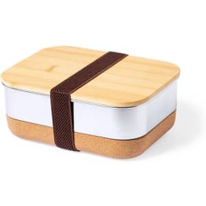 A two-tier lunch box with a bamboo lid, silver top, and cork base, secured with a brown strap.