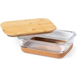 A glass lunch box with a bamboo lid and a cork base. It features a transparent design and is rectangular in shape.