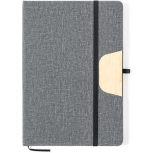 A grey notebook with a textured cover, a bamboo accent on the side, and an elastic band closure.
