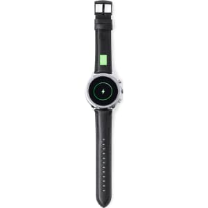 A black smartwatch with a round face and a sleek design, featuring a charging indicator.