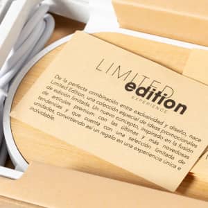 A wireless charger in a wooden box, featuring a card with information and branding, showcasing a limited edition design.