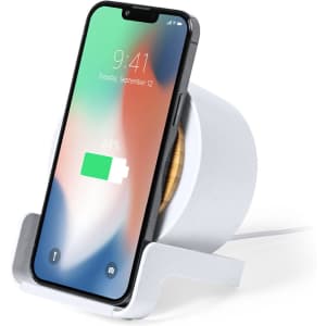A white multifunction lamp with a wooden base and a smartphone displaying a battery charge indicator.