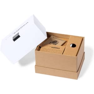 A brown cardboard box partially open, containing the Sadow Multifunction Lamp with paperwork inside. The box has a white top.