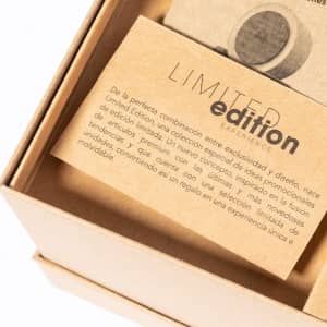 A tan card with text inside a box, featuring a round object and a logo in the background.