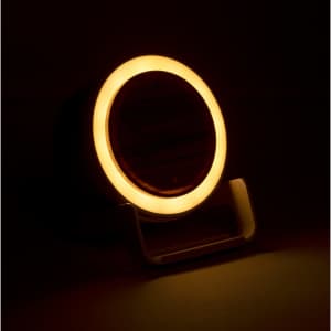 A multifunction lamp with a circular warm light glow, featuring a sleek design and a stand.