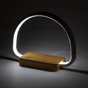 A modern lamp with a curved light encased in a white material and a wooden base. Features a sleek design.